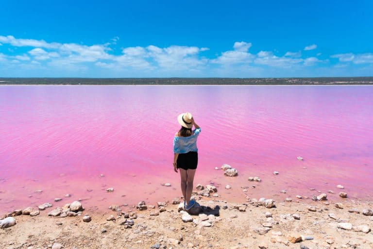 woman standing at pink lake
