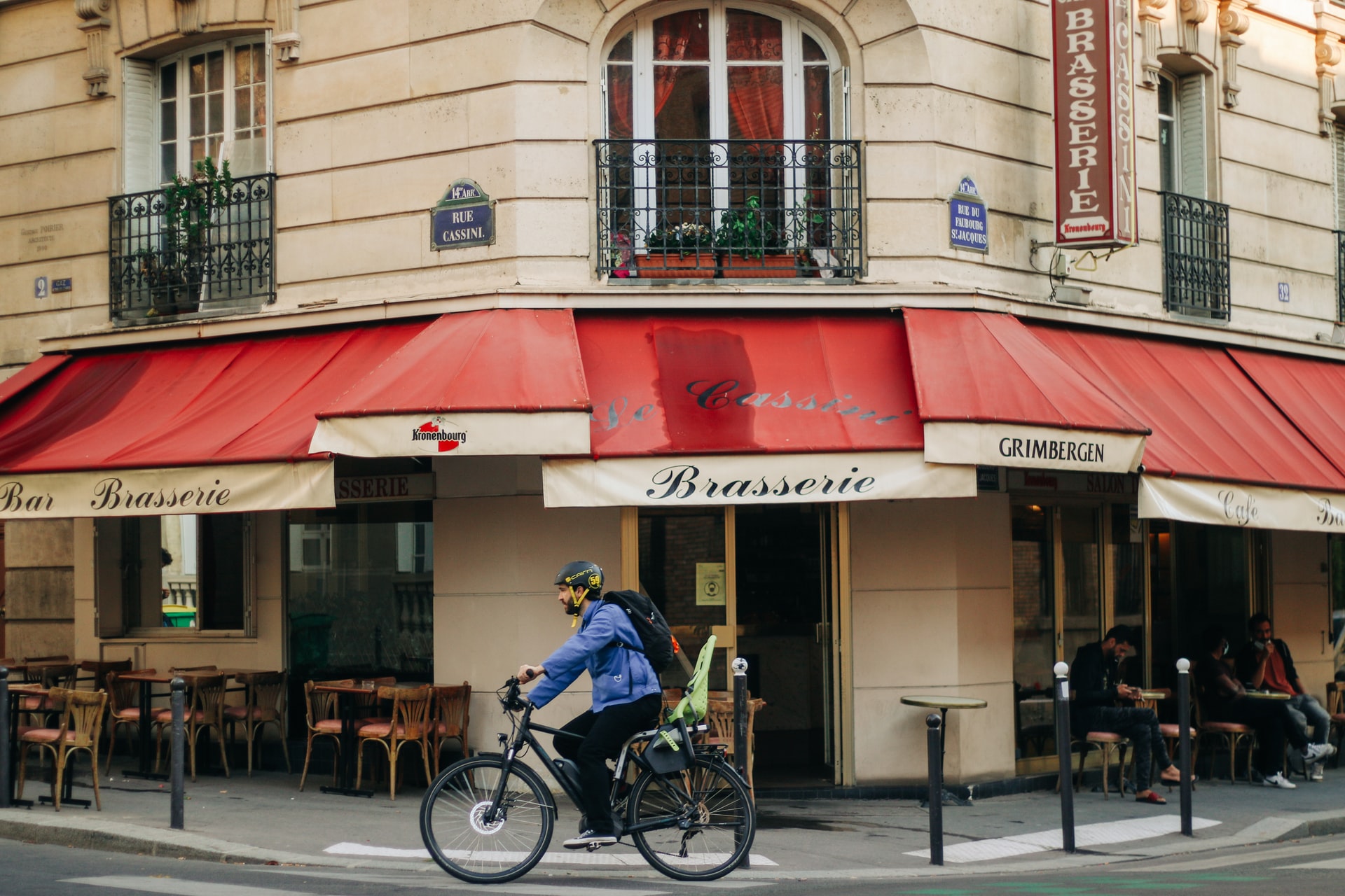 a man cycling past an eatery in paris