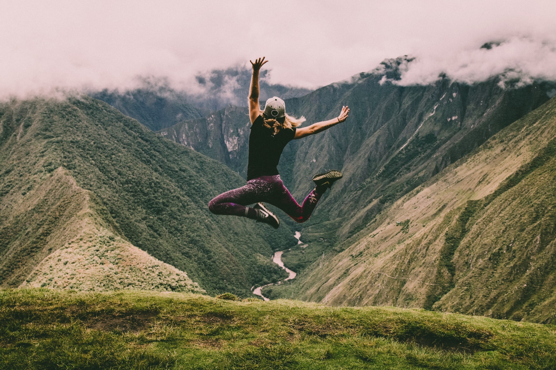 Girl jumping in the air against backdrop of the Inca Trail landscape