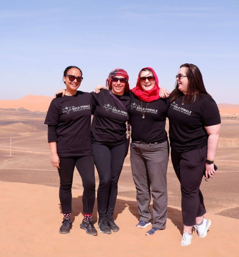 women on a women only tour in Morocco stating in the Sahara laughing