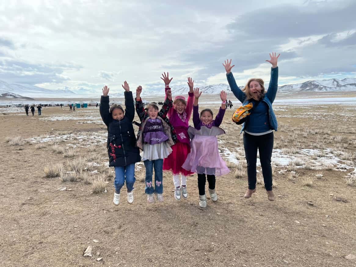 Jess Whitkins in Mongolia, posing with kids on the Sofe Travel Women-Only tour