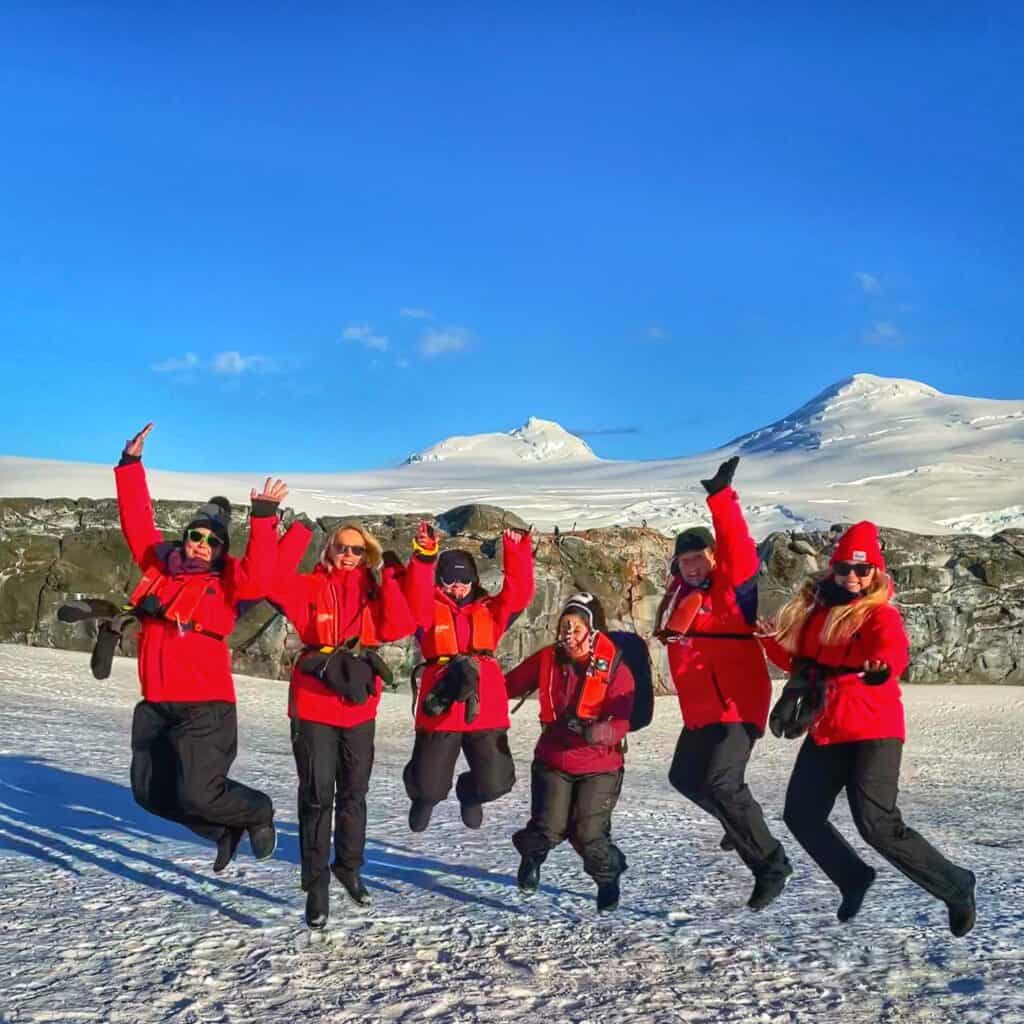 A group of SoFe women jumping in the snow in Antarctica