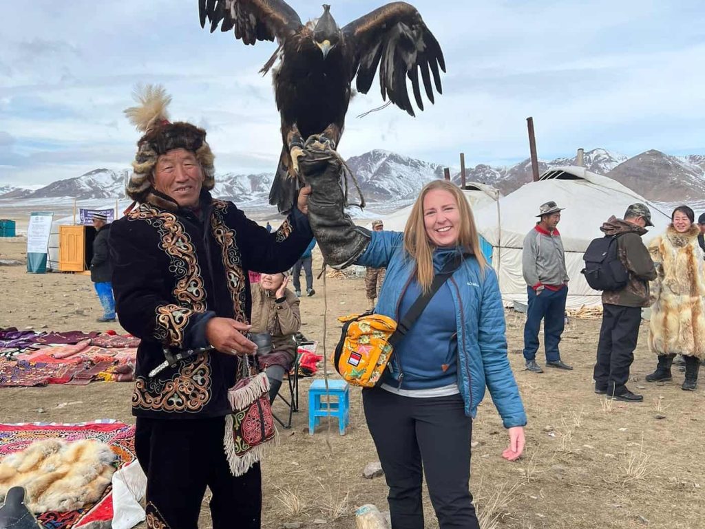 women holding an eagle at the golden eagle festival in Mongolia on a women only tour