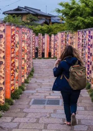woman traveling solo in Japan walking through a temple with a purple backpack