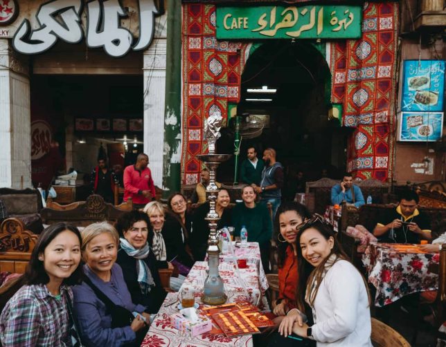 women sitting down in a market Solo Network Egypt Female Tours
