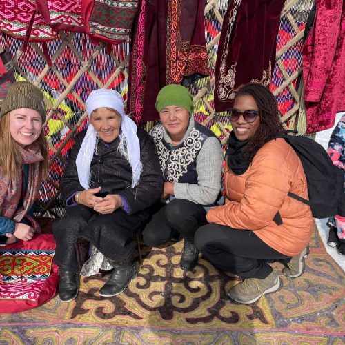 women on an all women tour smiling with eagle hunters in Mongolia