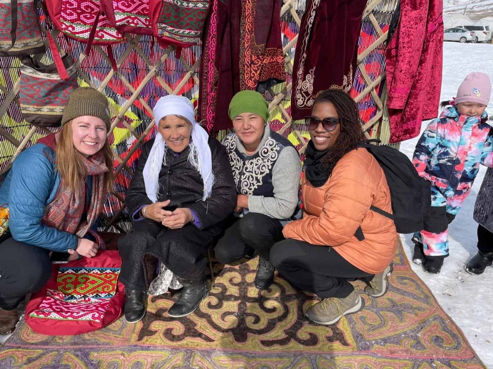 women on an all women tour smiling with eagle hunters in Mongolia