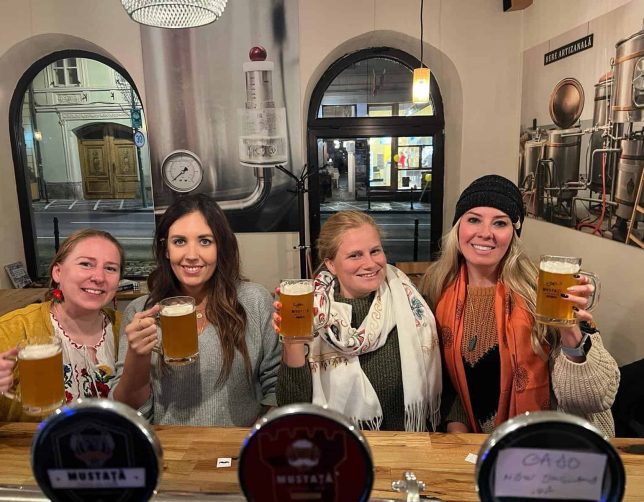solo female travelers in Romania drinking beer at a pub